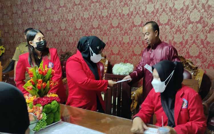 Bupati Seruyan Yulhaidir menyerahkan bantuan untuk mahasiswa Seruyan yang sedang menyelesaikan tugas akhir (Foto : Prokom Seruyan)