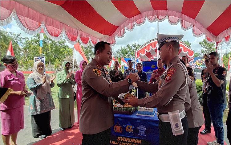 Kapolres Sukamara, AKBP Dewa Made Palguna menyerahkan potong tumpeng kepada anggota termuda pada acara Hari Lalu Lintas Bhayangkara Ke 67, Kamis, 22 September 2022. (FOTO: NORHASANAH)