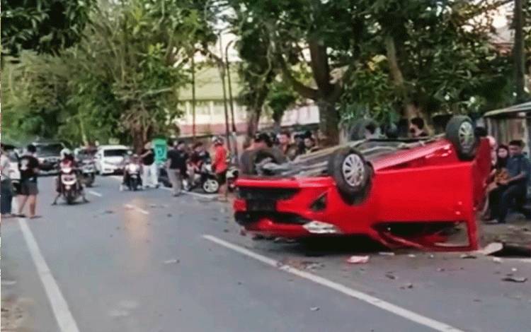 Mobil mini bus terbalik seusai menabrak 5 kendaraan bermotor yang terparkir di Jalan Kartini Kota Palangka Raya, Minggu, 25 September 2022. (PARLIN TAMBUNAN)