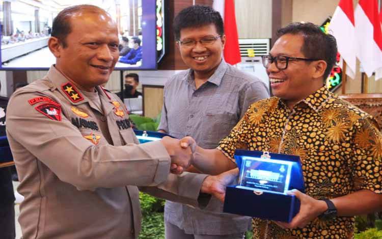Kapolda Kalteng Irjen Nanang Avianto memberikan cindera mata kepada salah satu Nara sumber dari Dewan Pers, Selasa 27 September 2022. (POTO: PARLIN TAMBUNAN)