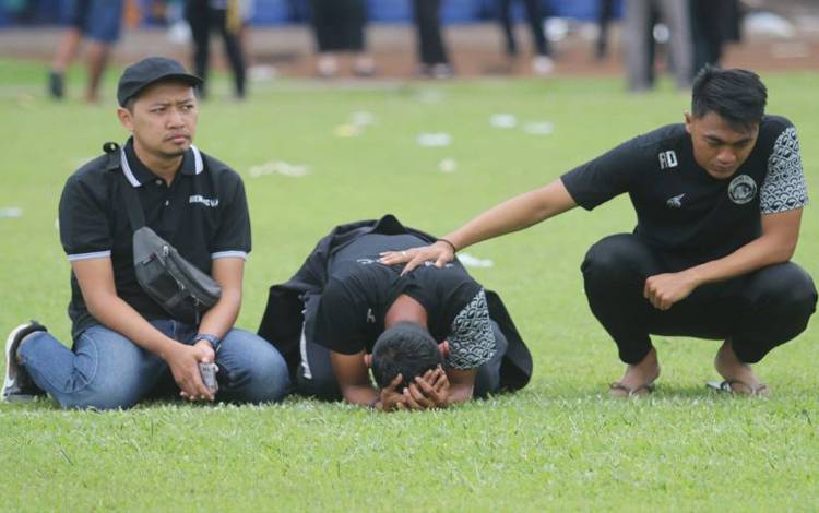 Pemain Arema FC menangis saat melakukan tabur bunga di Stadion Kanjuruhan, Kabupaten Malang, Senin (3/10/2022) untuk mengenang korban kerusuhan. (ANTARA/ Prasetia Fauzani)
