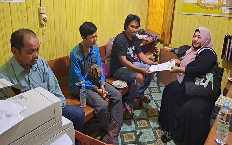 Kanit Intelkam Polsek Bulik Bripka Ahmad Hudi mengembalikan surat perjanjian jual beli tanah. Setelah Dimediasi, kedua belah pihak memilih untuk berdamai. (FOTO : HENDI NURFALAH)