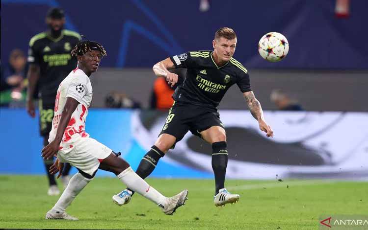 Gelandang Real Madrid asal Jerman Toni Kroos (kanan) berebut bola dengan gelandang Leipzig Amadou Haidara saat laga Grup F Liga Champions kontra RB Leipzig di Leipzig, Jerman, pada 25 Oktober 2022. (AFP/RONNY HARTMANN)