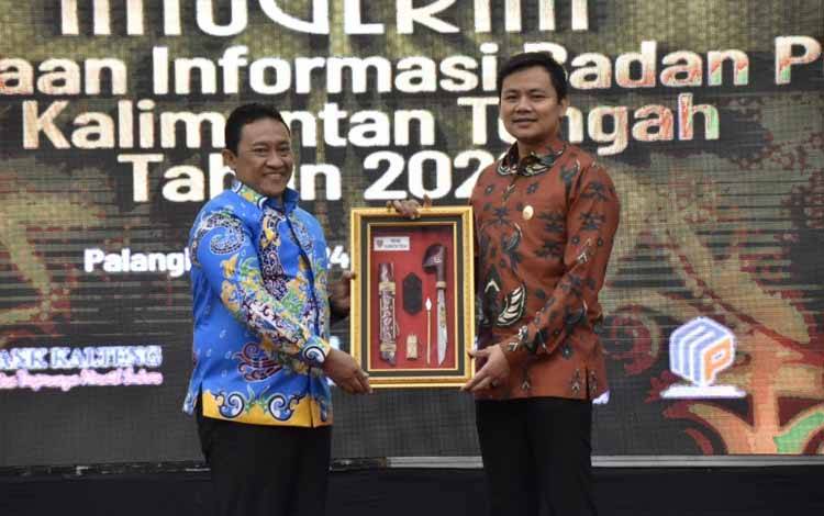 Wakil Gubernur Kalimantan Tengah, Edy Pratowo (kanan) saat memberikan cinderamata Wakil Ketua Komisi Informasi (KI) Pusat, Arya Sandhiyudha (kiri) Kamis malam, 24 November 2022. (HERMAWAN DP)