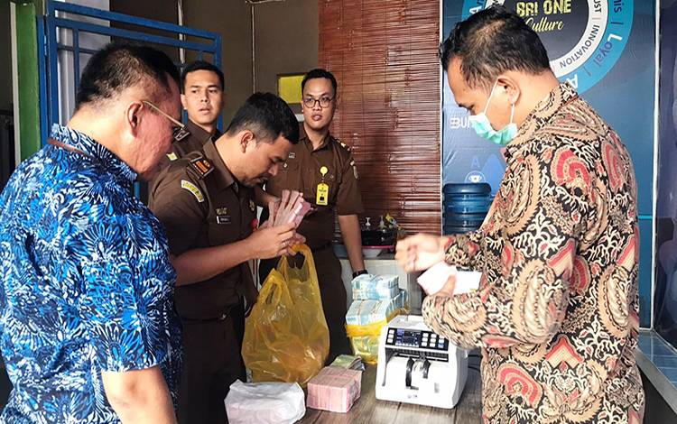 Plh. Kasi Pidsus Kejari Lamandau, Yudo Adiananto memeriksa uang yang disita dari Kontraktor Pelaksana dan Konsultan Pengawas Proyek SAB-NSP. (FOTO : HENDI NURFALAH)