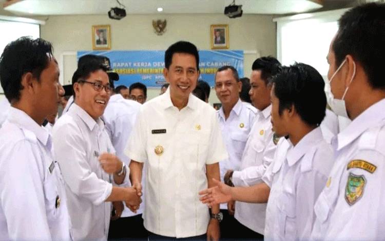 Kepala Desa (Kades) se Barito Utara saat bersalaman dengan bupati Barito Utara usai pembukaan rapat kerja DPC Apdesi di aula BappedaLitbang. (Foto: Dhani)