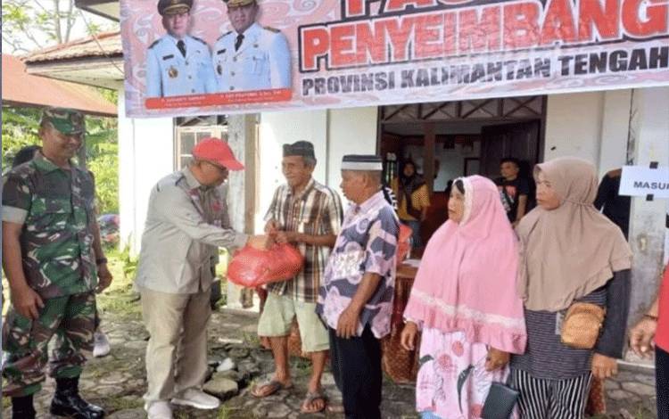 Kepala Dinas Ketahanan Pangan Kalimantan Tengah Riza Rahmadi menyerahkan paket bahan pokok kepada perwakilan warga saat pembukaan pasar penyeimbang di Desa Cempaka Mulia Barat Kecamatan Cempaga Kabupaten Kotawaringin Timur, Minggu (11/12/2022). (ANTARA/HO-DKP Kalteng)