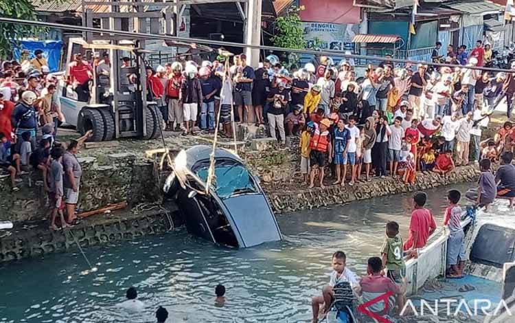 Satu unit mobil mengalami musibah terjun ke laut di Kota Baubau, Sultra, Sabtu (14/1/2023). Nampak proses evakuasi dilakukan. ANTARA/Yusran