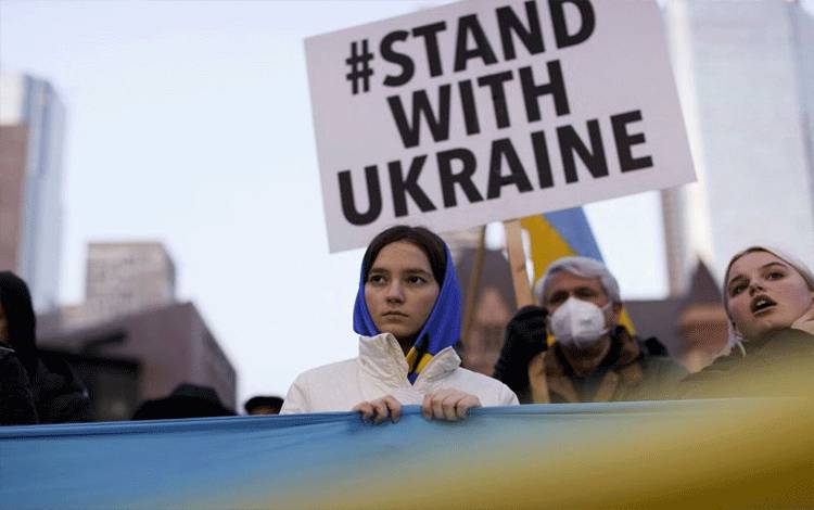 Warga menghadiri penyalaan lilin bagi Ukraina pada Sabtu Suci Ortodok, di Nathan Phillips Square di Toronto, Ontario, Kanada, Sabtu (23/4/2022). (REUTERS/Carlos Osorio/HP/djo)