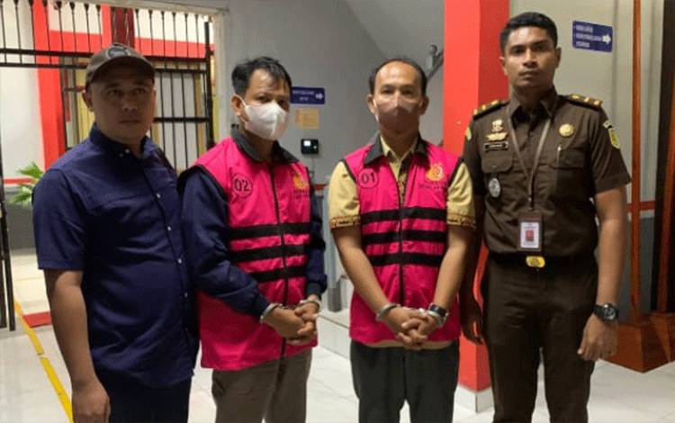 Kepala Desa Tarusan Danum AP bersama bendahara desa itu APBH diapit petugas Kejari Katingan dengan tangan terborgol. Keduanya diduga melakukan tindak pidana korupsi APBDes.