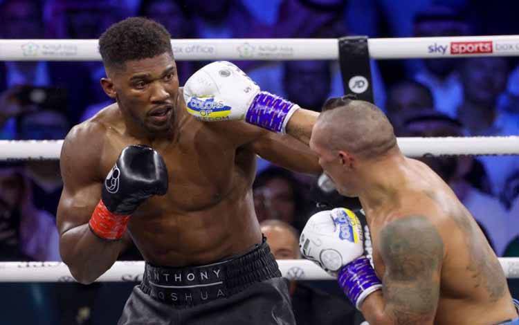 Arsip foto - Anthony Joshua (kiri) dan Oleksandr Usyk (kanan) sedang bertarung pada pertarungan tinju kelas berat versi WBA, WBO, IBO, dan IBF di King Abdullah Sports City Arena, Jeddah, Arab Saudi (20/8/2022). ANTARA/AFP/GIUSEPPE CACACE