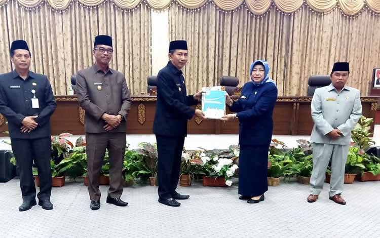 Ketua DPRD Barito Utara Hj Mery Rukaini didampingi Wakil Ketua II Sastra Jaya menyerahkan kepada Bupati Barito Utara H Nadalsyah hasil reses masa sidang II, Rabu 29 Maret 2023. (foto: Dhani)