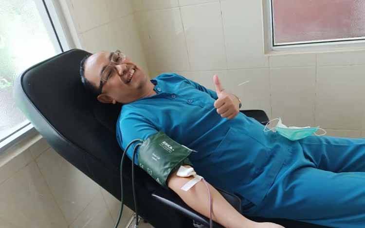 dr Franky Luhulima saat melakukan aksi donor darah (FOTO: DOKUMEN PRIBADI)