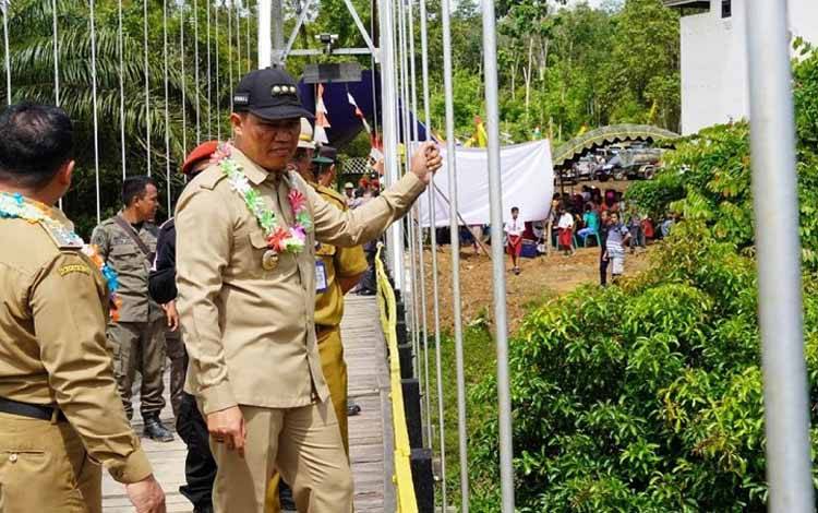 Usai diresmikan, Bupati Lamandau Hendra Lesmana periksa kontruksi jembatan Belibi yang ada di Kecamatan Menthobi Raya. (FOTO : HENDI NURFALAH)