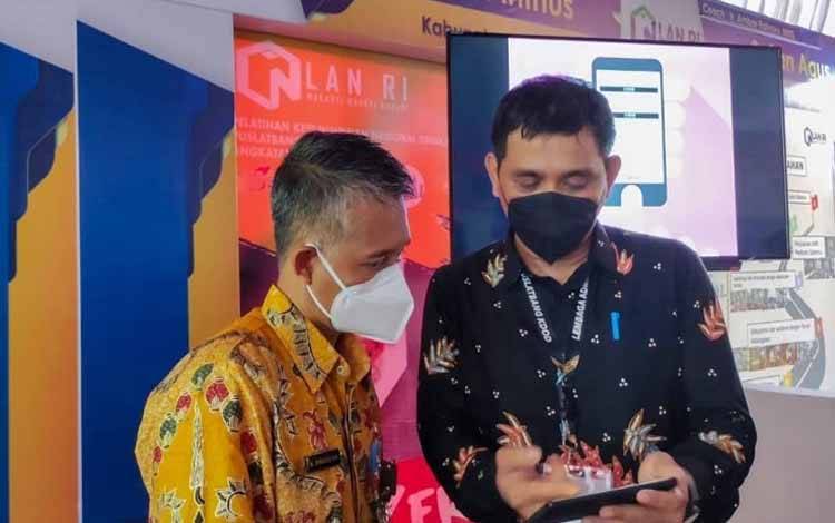 Plt Kepala Disdukcapil Kamini Anthus berbincang dengan Sekda Muhamad Irwansyah saat menghadiri pameran inovasi di Samarinda.(FOTO : HENDI NURFALAH)