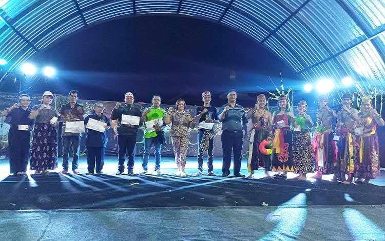 Kepala Dinas Kebudayaan, Pariwisata, Kepemudaan dan Olahraga Kabupaten Barito Timur, Herawani berfoto dengan perwakilan masing-masing sanggar tari usai menyerahkan piagam penghargaan dan uang pembinaan pada malam kedua Festival Budaya Nansarunai Jajaka 2023, Sabtu, 6 Mei 2023. (FOTO: BOLE MALO)