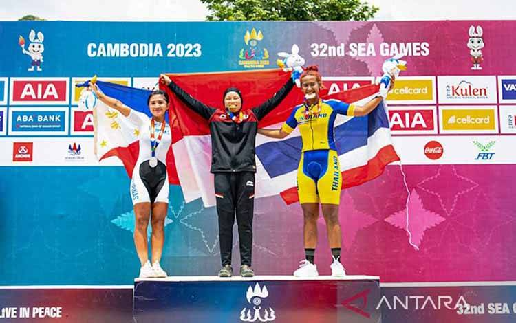 Dara Latifah (tengah) mengumandangkan lagu Indonesia Raya dan membuat Merah Putih berkibar pada SEA Games XXXII/2023 Kamboja setelah menjadi yang terbaik pada nomor XCE putri di Kulen Mountains, Siem Rep, Kamboja, Senin (8/5/2023). ANTARA/HO-PB ISSI/Nick Hanoatubun/aa. (Handout PB ISSI/Nick Hanoatubun)