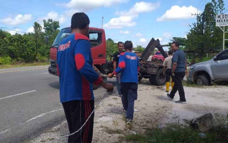 Tim Tiger Katingan bersama Satgas Dinas Lingkungan Hidup mengevakuasi mobil Hilux yang terperosok di parit di Jalan Tjilik Riwut Km 8 Kasongan, Jumat, 12 Mei 2023.