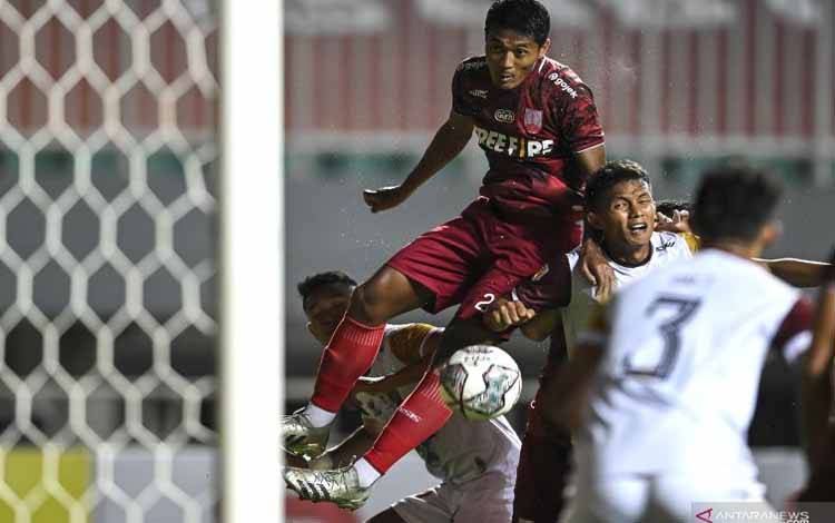 Pesepak bola Persis Solo Arif Budiyono (kiri) berusaha menyundul bola di depan gawang Sriwijaya FC dalam lanjutan babak delapan besar Liga 2 di Stadion Pakansari, Kabupaten Bogor, Jawa Barat, Minggu (19/12/2021). ANTARA FOTO/M Risyal Hidayat/aww