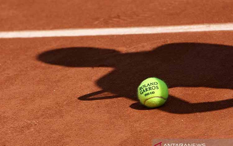 ilustrasi - Bola resmi turnamen tenis dengan bayang-bayang seorang pemain tenis diatas tanah. ANTARA/Shutterstock/pri.