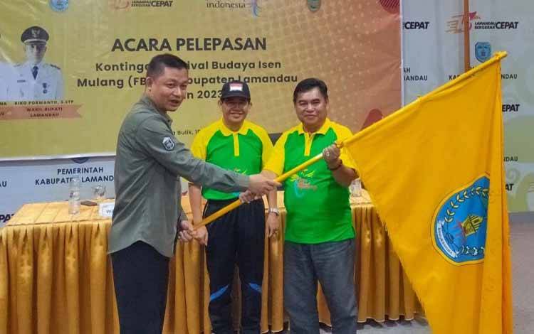Wakil Bupati Riko Porwanto menyerahkan pataka Kabupaten Lamandau kepada perwakilan kontingen. (FOTO : HENDI NURFALAH)