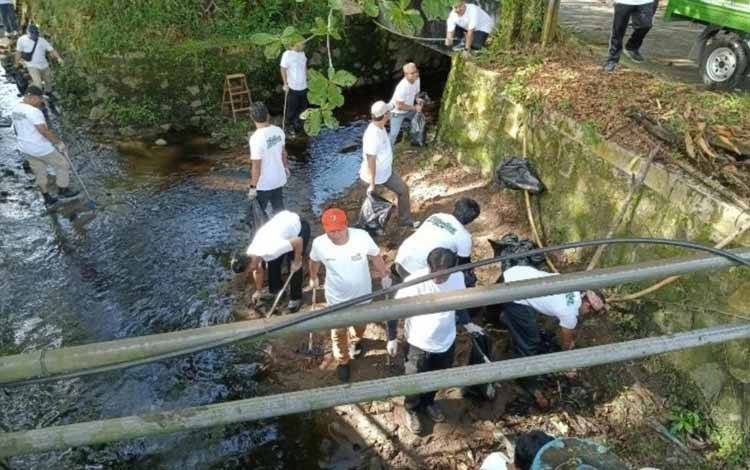 Kepala Dinas Lingkungan Hidup Kota Palangka Raya Achmad Zaini (topi oranye) saat membersihkan saluran air (Foto : DLH Kota Palangka Raya)