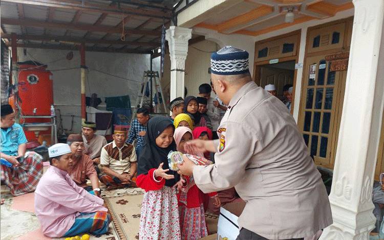 Aiptu Nana Sumarna membagikan cemilan kepada anak-anak didiknya di Lembaga Pendidikan Alquran (LPQ) Bahrul Ulum, Kota Jambi, Selasa (27/6/2023). (ANTARA/Laily Rahmawaty)