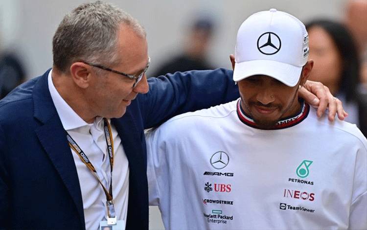 Formula One Group CEO Stefano Domenicali (L) speaks with Mercedes' British driver Lewis Hamilton after the Monaco Formula 1 Grand Prix at the Monaco street circuit in Monaco, on May 29, 2022. (Photo by ANDREJ ISAKOVIC / AFP) (AFP/ANDREJ ISAKOVIC)