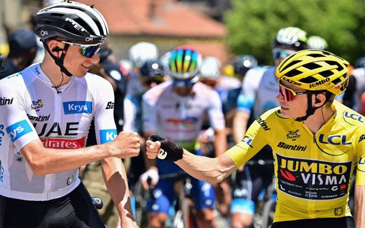 Pebalap tim UAE Emirates Tadej Pogacar (kiri) asal Slovenia menyapa pebalap tim Jumbo-Visma Jonas Vingegaard (kanan) asal Denmark sebelum start etape 9 Tour de France, 182,5km dari Saint-Leonard-de Noblat ke Puy de Dome, Prancis. (9/7/2023) (AFP/MARCO BERTORELLO)