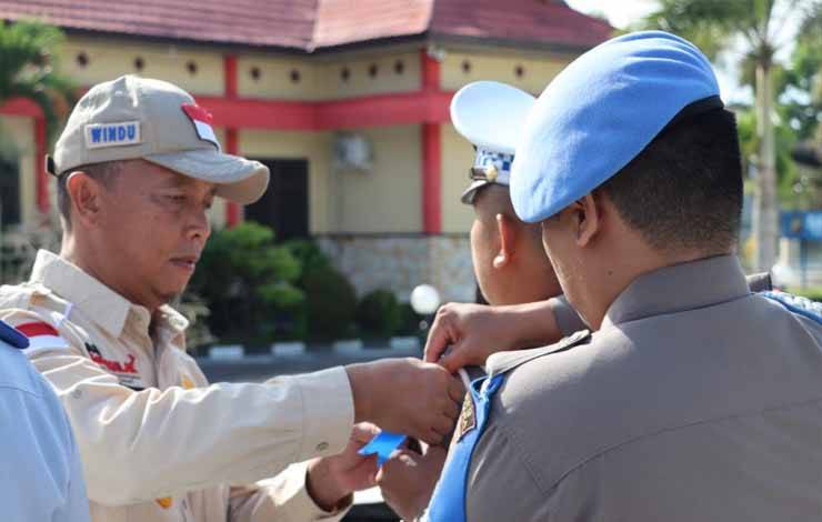 Bupati Sukamara Windu Subagio menyematkan pita biru kepada anggota tanda dilaksanakannya Operasi Patuh Telabang, Senin 10 Juni 2023. (NORHASANAH)