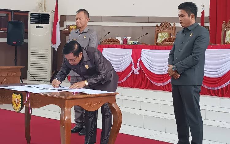 Ketua DPRD Gunung Mas Akerman Sahidar saat menandatangani persetujuan bersama dengan Kepala daerah terhadap enam raperda, Selasa, 11 Juli 2023. (FOTO: RISKA YULYANA)?