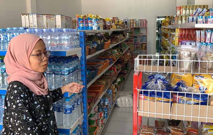 Adik pemilik toko Indomarkomarket Fitri saat menunjukkan rak kaleng susu, Rabu, 12 Juli 2023 (Foto : Pathur)