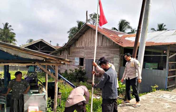 Polres Pulang Pisau beserta jajaran saat melakukan imbauan serta pemasangan bendera merah putih didepan disalah satu rumah warga. ( FOTO : M PRADILA KANDI )
