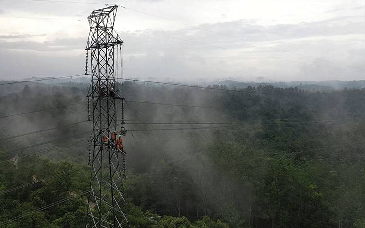 Petugas PDKB PLN melakukan pemeliharaan isolator pada jalur interkoneksi Kalsel?dan?Kaltim. (FOTO: PLN UID KALSELTENG)