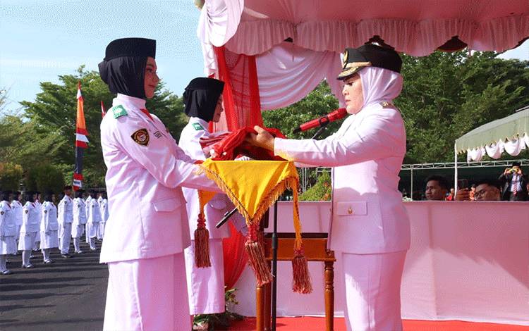 Wakil Bupati Seruyan, Iswanti ?sebagai inspektur?Upacara?Peringatan? HUT?RI??ke- 78 tingkat Kabupaten Seruyan, menyerahkan bendera merah putih untuk dikibarkan kepada petugas Paskibraka Seruyan, Kamis, 17 Agustus 2023. (Foto : PROKOM SERUYAN)