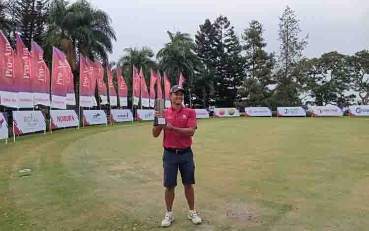 Pegolf Indonesia Kevin Caesario Akbar berpose dengan trofi juara The Indonesia The Indonesia Pro-Am presented by Combiphar & Nomura, di Gunung Geulis Country Club, Kabupaten Bogor, Jumat (18/8/2023). (ANTARA/RAUF ADIPATI)