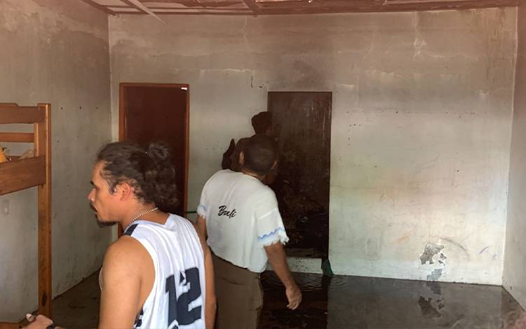 Penjaga Kos Zerolado Eduard bersama warga sekitar mengecek kamar kos yang hampir terbakar. (FOTO: PATHUR)