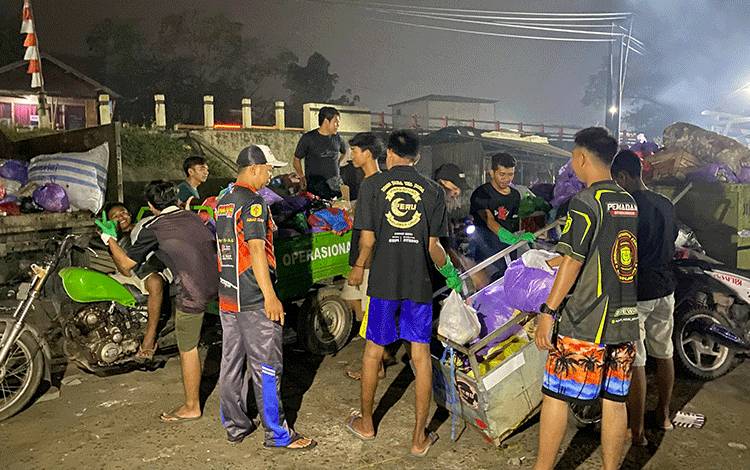 Relawan PMK Peru saat mengangkut sampah rumah tangga warga RT 18 Kelurahan Ampah Kota menuju TPS. (FOTO: IST