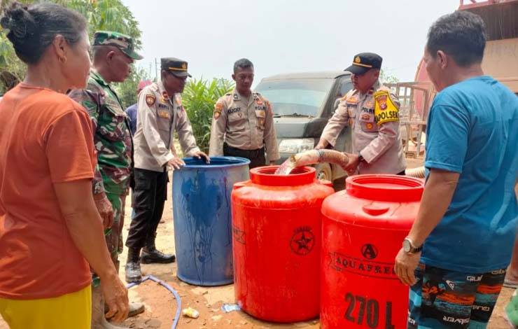 Kapolsek Arut Utara IPDA Edi Hariyanto beserta jajaran saat menyalurkan air bersih pada warga Desa Sukarami. (Foto : Polsek Aruta)