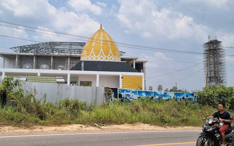 Tampak salah satu warga melintas di sekitar lokasi proyek pembangunan Masjid Agung Kabupaten Lamandau. (FOTO : HENDI NURFALAH)