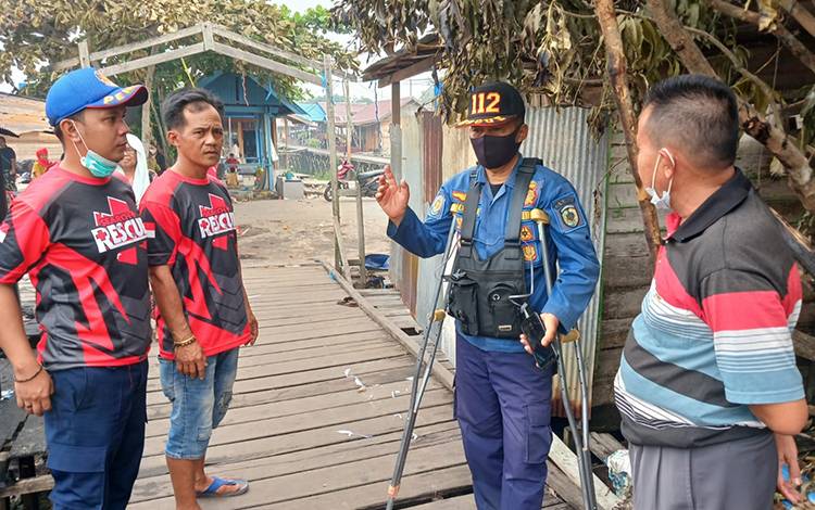 Kepala Seksi Pengendali Operasi Komunikasi Penyelamatan DPKP Kota Palangka Raya, Sucipto saat meminta keterangan dari warga terkait kejadian kebakaran. (FOTO: PATHUR)