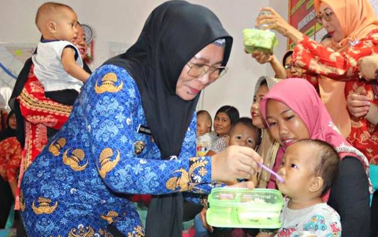 Pj Bupati Pulang Pisau, Nunu Andriani saat memberi makanan sehat untuk salah seorang balita pada acara Kick Off Gemar Posting. Selasa, 17 Oktober 2023. (FOTO : M PRADILA KANDI)