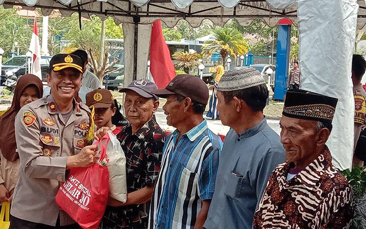Wakapolres Sukamara, Kompol Budi Nugroho menyerahkan paket sembako kepada masyarakat, Sabtu, 21 Oktober 2023. (FOTO:NORHASANAH)