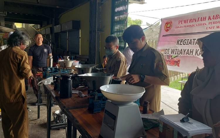Petugas dari Bidang Perdagangan DisperindagkopUKM Kabupaten Kotawaringin Barat berikan pelayanan tera/tera ulang timbangan di sejumlah pasar. (FOTO: Muhammad Suhendra).