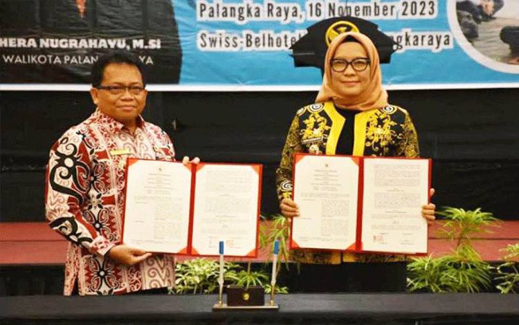 Pj Bupati Kapuas Erlin Hardi (kiri) dan Pj Wali Kota Palangka Raya Hera Nugrahayu (kanan) usai menandatangani nota kesepakatan naskah kerja sama pembangunan antardaerah, di Palangka Raya, Kamis (16/11/2023). ANTARA/HO-Diskominfo Kapuas.