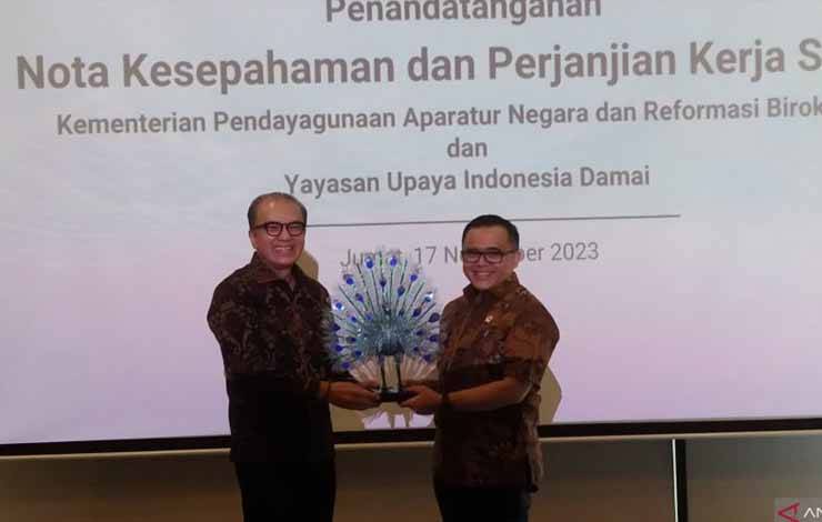 Menteri PANRB Abdullah Azwar Anas (kanan) menerima cenderamata oleh Pimpinan Yayasan Upaya Indonesia Damai (UID) Tantowi Yahya di sela penandatanganan kerja sama digitalisasi pemerintahan di Denpasar, Jumat (17/11/2023) ANTARA/Dewa Ketut Sudiarta Wiguna