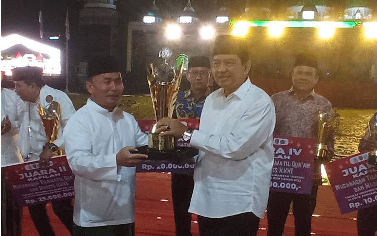Gubernur Kalteng Sugianto Sabran saat menyerahkan piala bergilir pada Pj. Bupati Kobar Budi Santosa atas keberhasilan Kabupaten Kobar mendapatkan juara umum dalam MTQH ke 31 Kalteng dalam malam penutupan yang digekar di Stadion Sampuraga, Pangkalan Bun, Jumat, 24 November 2023.
