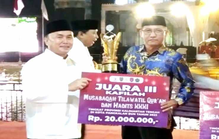 Gubernur Kalteng,Sugianto Sabran menyerahkan piala dan uang pembinaan kepada kafilah Barito Utara yang meraih juara terbaik III pada MTQH ke XXXI tingkat Provinsi Kalteng yang diterima oleh Sekretaris Umum LPTQ Barito Utara Saiful Fahmi, Jumat malam 24 November 2023.(foto: Dhani)