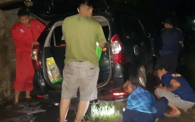 Tim penyelamatan DPKP Palangka Raya saat mengecek kondisi mobil ban depan terperosok. (FOTO: IST)