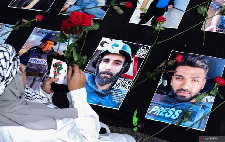 Warga menaruh bunga mawar di atas sejumlah foto jurnalis Gaza, Palestina yang tewas saat bertugas pada aksi damai di Solo, Jawa Tengah, Selasa (17/11/2023). ANTARAFOTO/Maulana Surya/Spt. (ANTARA FOTO/Maulana Surya)